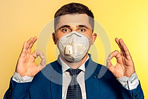 Strong man, businessman in tie and medical mask demonstrates confidence at work in pandemic coronavirus. Shows confidence and calm