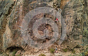 Strong man climbing a rock wall in a canyon - Climber training outdoor in a rocky spot - Travel, adrenaline and extreme dangerous