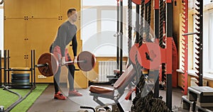 Strong man doing barbell exercise at the gym