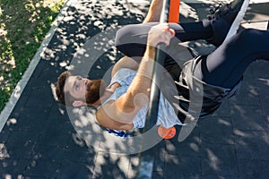 Strong man doing hanging leg raises for abdominal muscles