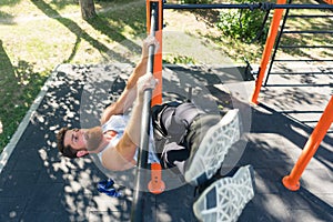 Strong man doing hanging leg raises for abdominal muscles during workout