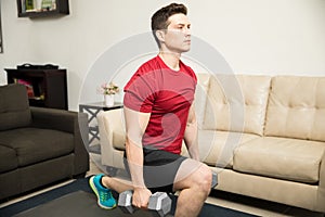 Strong man doing kneeling lunges at home