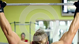 Strong man doing pull-ups on a bar in gym