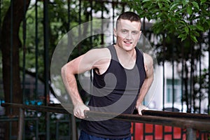 Strong man doing pull-ups on a bar outdoor