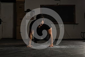 Strong man doing push-ups in a gym