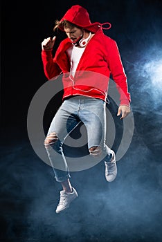 Strong man jumping, wear red hoodie over black background