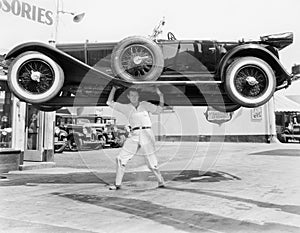 Strong man lifting a car over his head photo