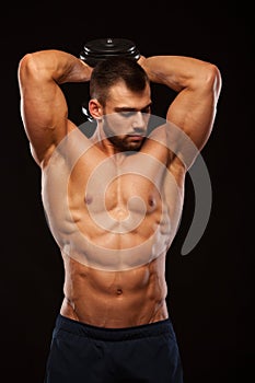 Strong man making exercises on triceps with a dumbbell. Close up shot training hands. Fitness Model showing his Torso