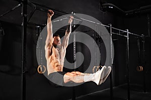 Man performing L-sit pull ups on bars, challenging bodyweight exercise. Bodyweight workout for physical and mental photo