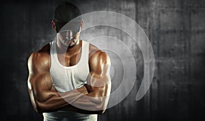 Strong man posing on a concrete background