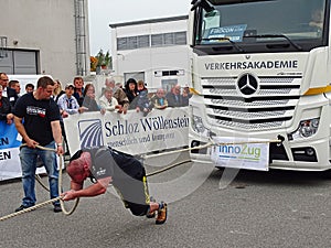 A strong man pulls a big truck