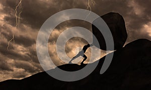 Strong man Pushing uphill Big Concrete Stone At rainy Cloudy Sky Thunder Storm . Businessman Push The Heavy Boulder up To The top photo