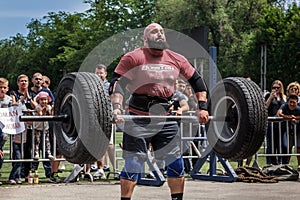Strong man raises a heavy barbell. Weightlifting