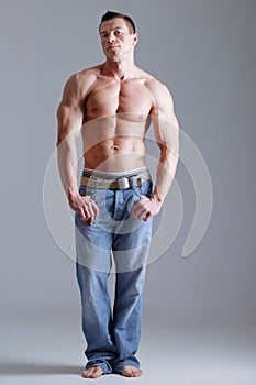 Strong man with relief body in jeans