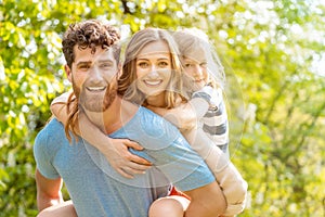 Strong man supporting his family by carrying wife and son piggyback