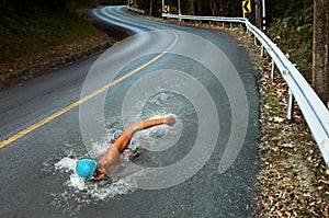 Forte uomo nuotare sul asfalto strade 