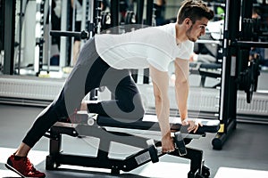 Strong man working with dumbbell in gym