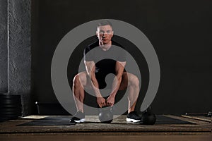 Strong man working out with kettlebell in gym