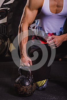 Strong and muscal man`s hand with a kettlebell photo