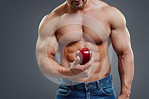 Strong Muscle Man holding a Red Apple