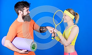 Strong muscles and body. Happy woman and bearded man workout in gym. Sporty couple training with fitness mat and tennis