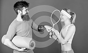 Strong muscles and body. Happy woman and bearded man workout in gym. Sporty couple training with fitness mat and tennis