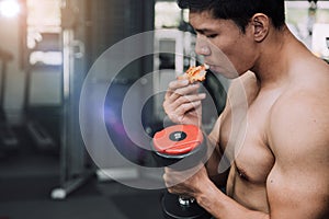 Strong muscular athlete men with pizza fast food. Unhealthy eating diet concept