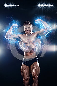 Strong muscular bodybuilder athlete man posing and pumping up muscles on black background. Workout bodybuilding concept.