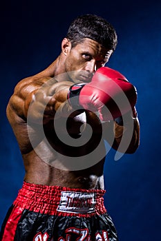 Strong muscular boxer in red boxing gloves. A man in a boxers s