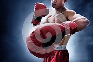 Strong muscular boxer on smoke background