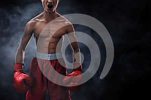 Strong muscular boxer on smoke backgrounds