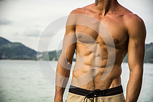 Strong muscular fit man posing in a swimsuit