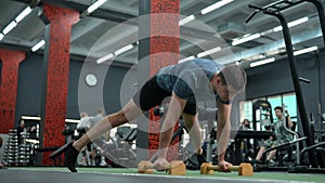Strong muscular fit man standing on hands holding on push-up stop. Athletic male taking static pose to strengthen
