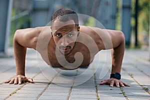 Strong muscular handsome man doing push ups