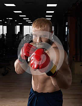 Strong muscular man boxing at the gym.