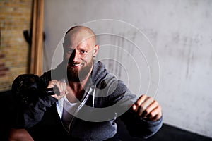 Strong muscular man doing squats with kettlebells photo