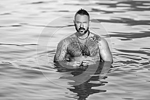 Strong muscular Man in water. Sexy male body with bare muscular naked torso. Summer relaxation concept. Calmness and