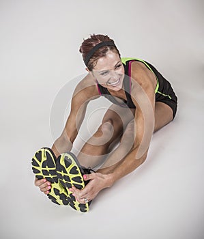 Strong muscular woman stretching before workout on white background