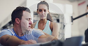Strong overweight man with training instructor, personal trainer, or coach exercising with gym equipment. Real
