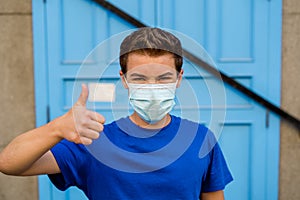 Strong portrait of young man with protective surgical face mask. Protection against COVID-19