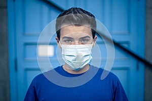 Strong portrait of young man with protective surgical face mask. Protection against COVID-19