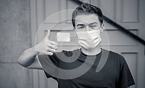 Strong portrait of young man with protective surgical face mask. Protection against COVID-19