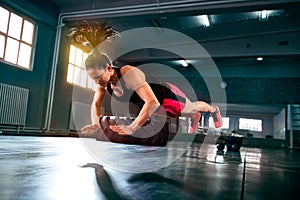 Strong powerful woman doing hard intense workout at gym