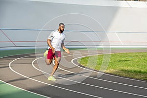 Strong purposeful sportive man on the running track