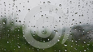 Strong rain water flushes against window glass and streaming down. Close-up. Raindrops on glass background in rainy