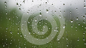 Strong rain water flushes against window glass and streaming down. Close-up. Raindrops on glass background in rainy