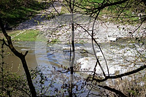 Strong river current, splash of water, waves and large stones.