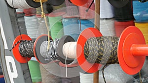 Strong ropes of different colors are wound on special reels on the counter in store