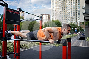 Strong Sport Man Is Training Outdoor City. Young man doing push-ups during outdoor