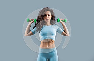 strong sport woman do weightlifting exercise with dumbbell in studio. sport woman